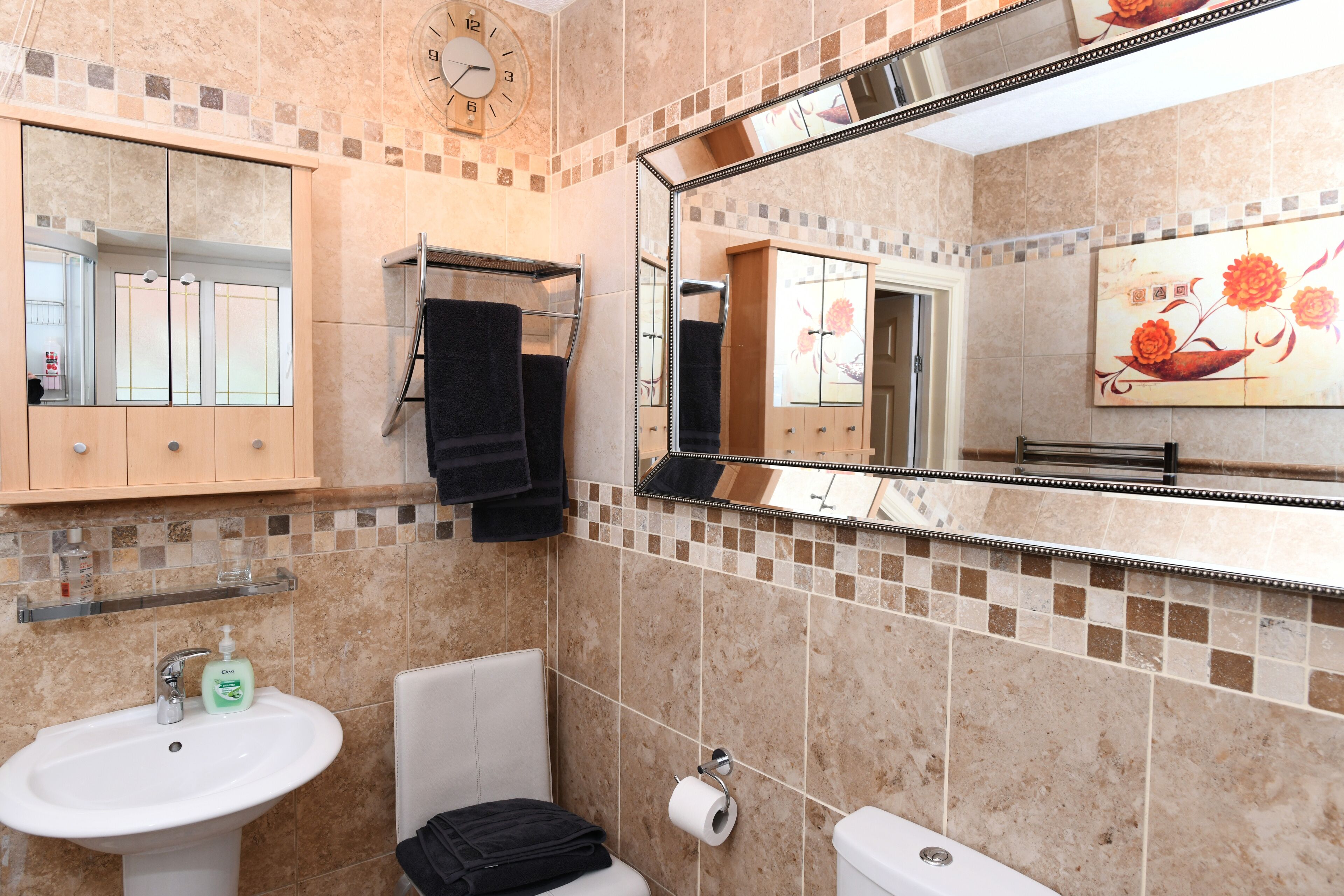 Un baño con lavamanos, inodoro y espejo.