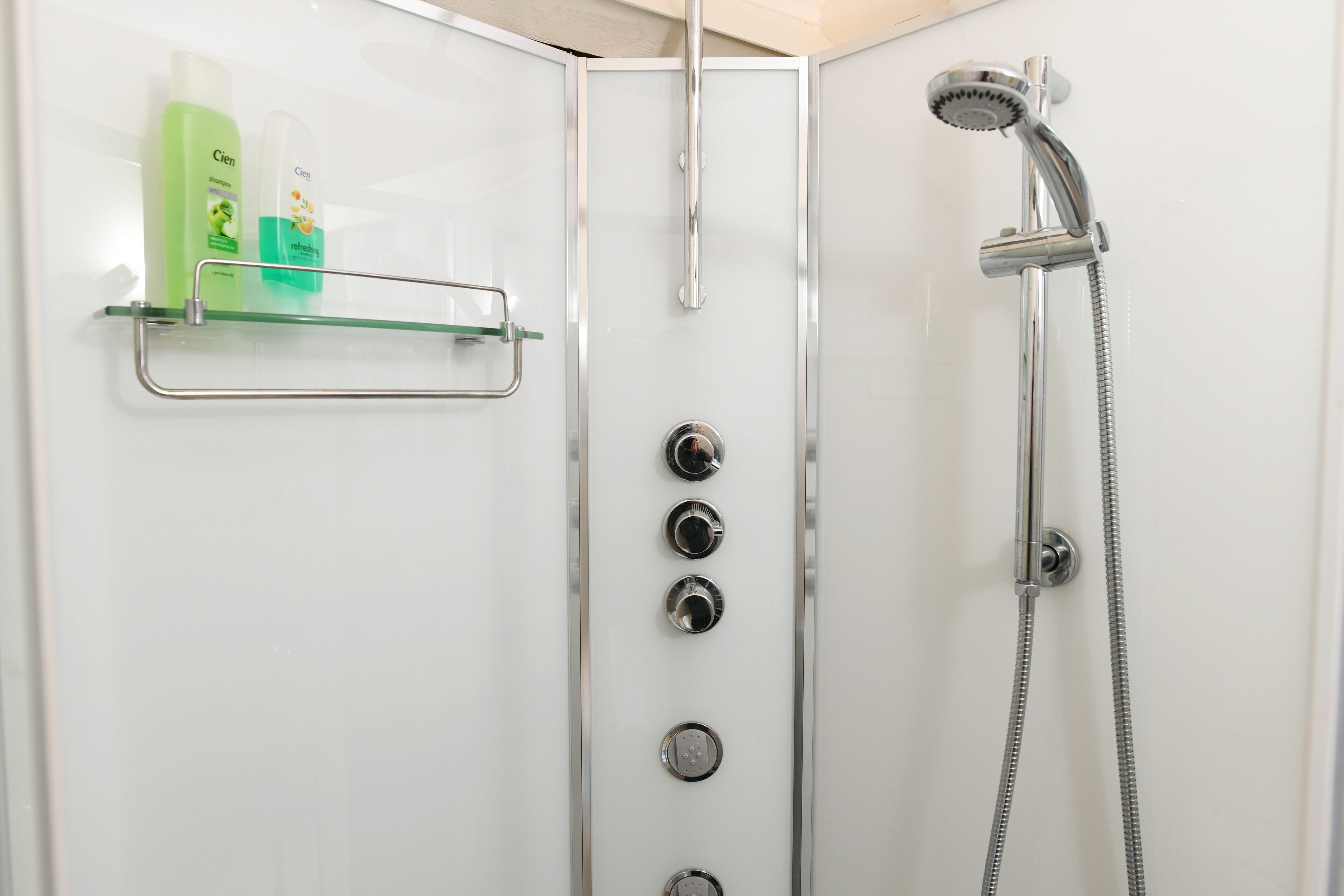 Doccia con porta in vetro, mancorrente e soffione.