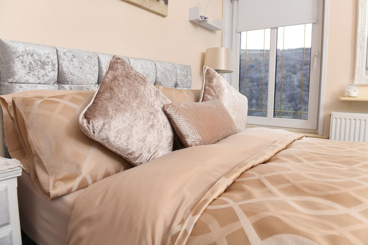 Un lit bien fait, avec une couvre-lit à motifs et plusieurs oreillers.