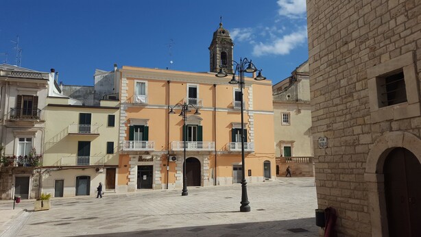 A historic square with a prominent building featuring a bell tower, a cobblestone plaza, and traditional architecture. - B&B Piazza Garibaldi (Santeramo in Colle)