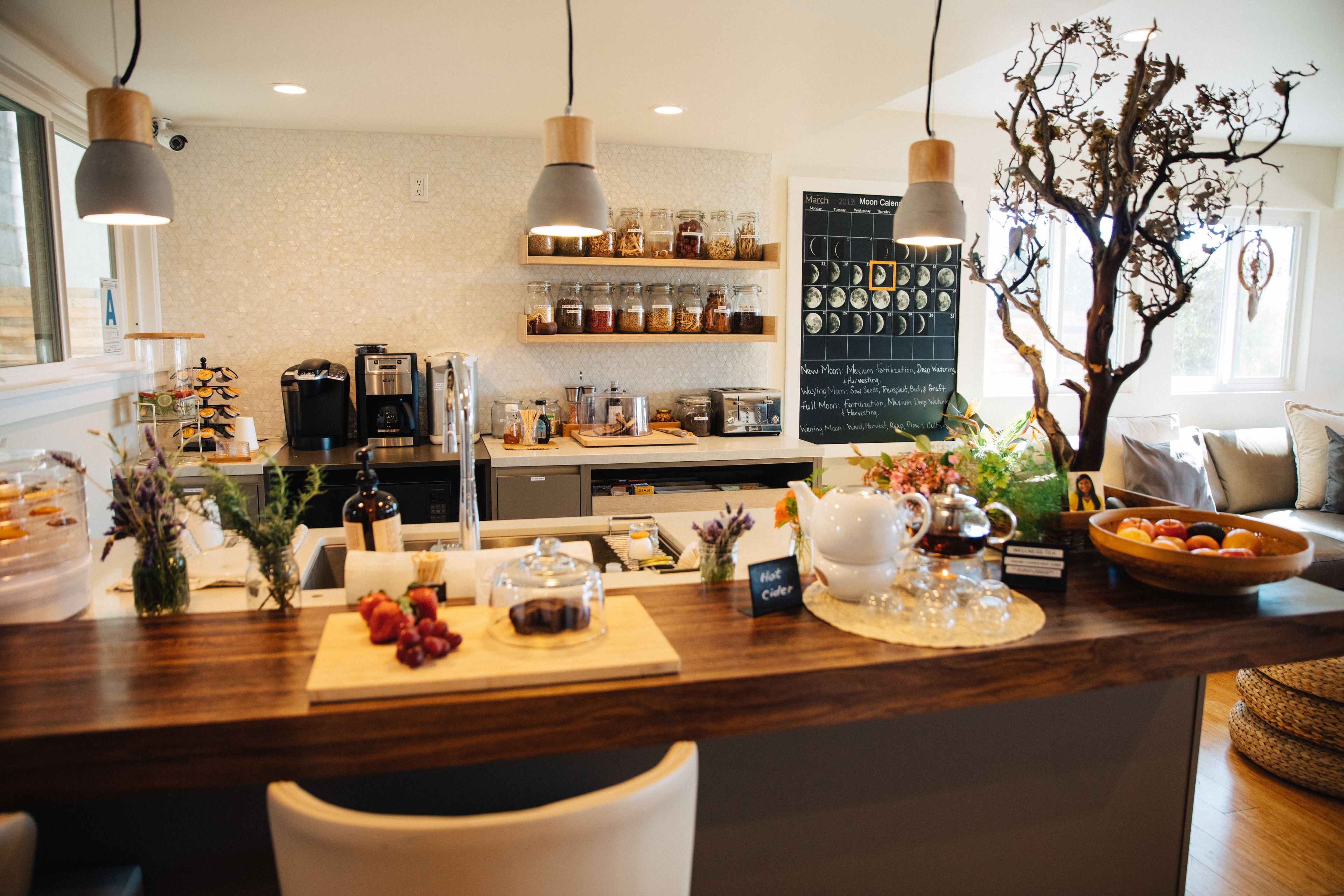 A restaurant counter with a wooden surface, various food items, and a chalkboard menu.