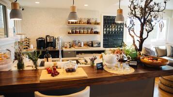 A restaurant counter with a wooden surface, various food items, and a chalkboard menu.