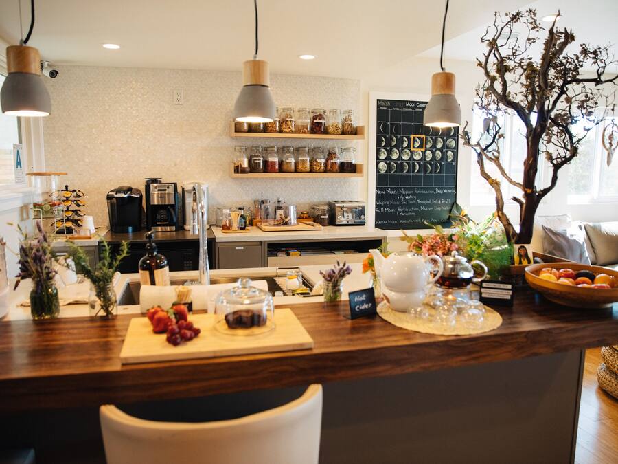 A restaurant counter with a wooden surface, various food items, and a chalkboard menu.