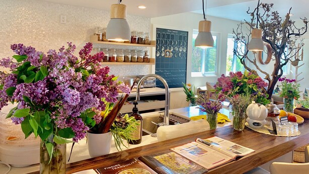A modern kitchen with a central island, pendant lighting, and a wall calendar. - Inn at Moonlight Beach (Encinitas)