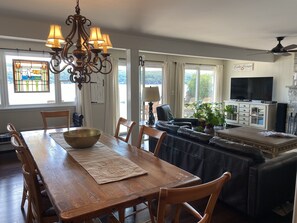Relax in the stylish living room with a comfortable sofa, dining table, and flat-screen TV.