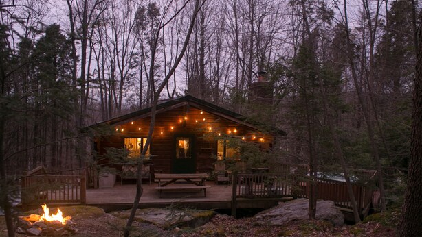 A rustic cabin with a porch, a fire pit, and a deck. -  Charming, Eco-Friendly Cabin Retreat, Heart of Deep Creek (Oakland)