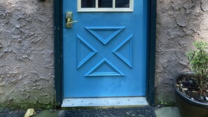 A blue door with a wreath and a welcome sign above it. -  Charming, Eco-Friendly Cabin Retreat, Heart of Deep Creek (Oakland)