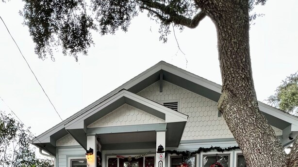 A house with a porch decorated for Christmas, including wreaths and a 'Merry Christmas' sign. - Pet friendly cottage 1 block to beach fenced in yard with pergola & outdoor tub (Gulfport)