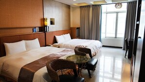 A hotel room with two beds, a glass table, wicker chairs, a TV, and a large window with curtains. - Cherng Yuan Hotel (Yuchi)