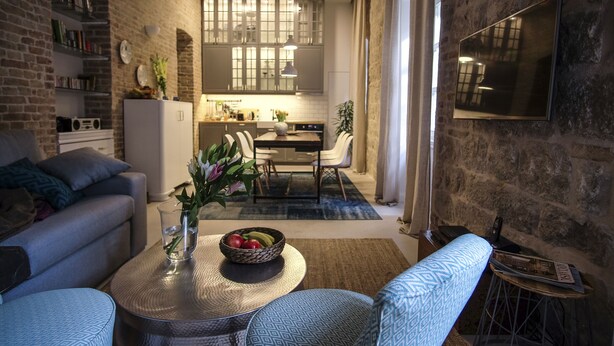 Una sala moderna con un sofá, una mesa de centro y una zona de comedor con sillas y una mesa.