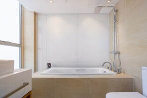 Ein modernes Badezimmer mit einer großen Badewanne, einer Dusche und einem WC.