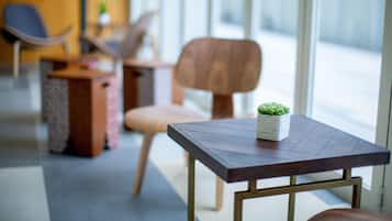 Um interior moderno com uma mesa de madeira, uma planta em vaso e uma cadeira.