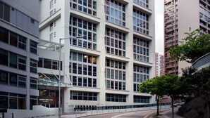 Un edificio moderno de varios pisos con fachada de vidrio y entrada curva.