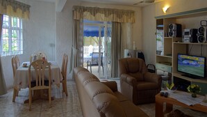 A living room with a sofa, chairs, a dining table, and a TV. -  A Villa in an idyllic setting, unparalleled service at a cool price (Flic en Flac)