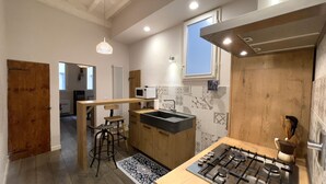 Una cocina moderna con estufa a gas, armarios de madera, microondas y ventana.