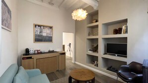Una sala de estar moderna con un sofá, una mesa de centro, un televisor y estanterías empotradas.
