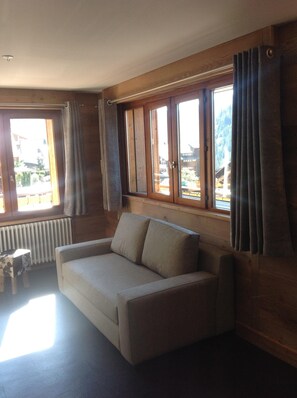 A room with a sofa, a radiator, and large windows with curtains. - Apartment/ flat - Chatel (Châtel)