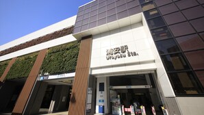 Um edifício moderno com uma placa que diz 'Urayasu Station'.