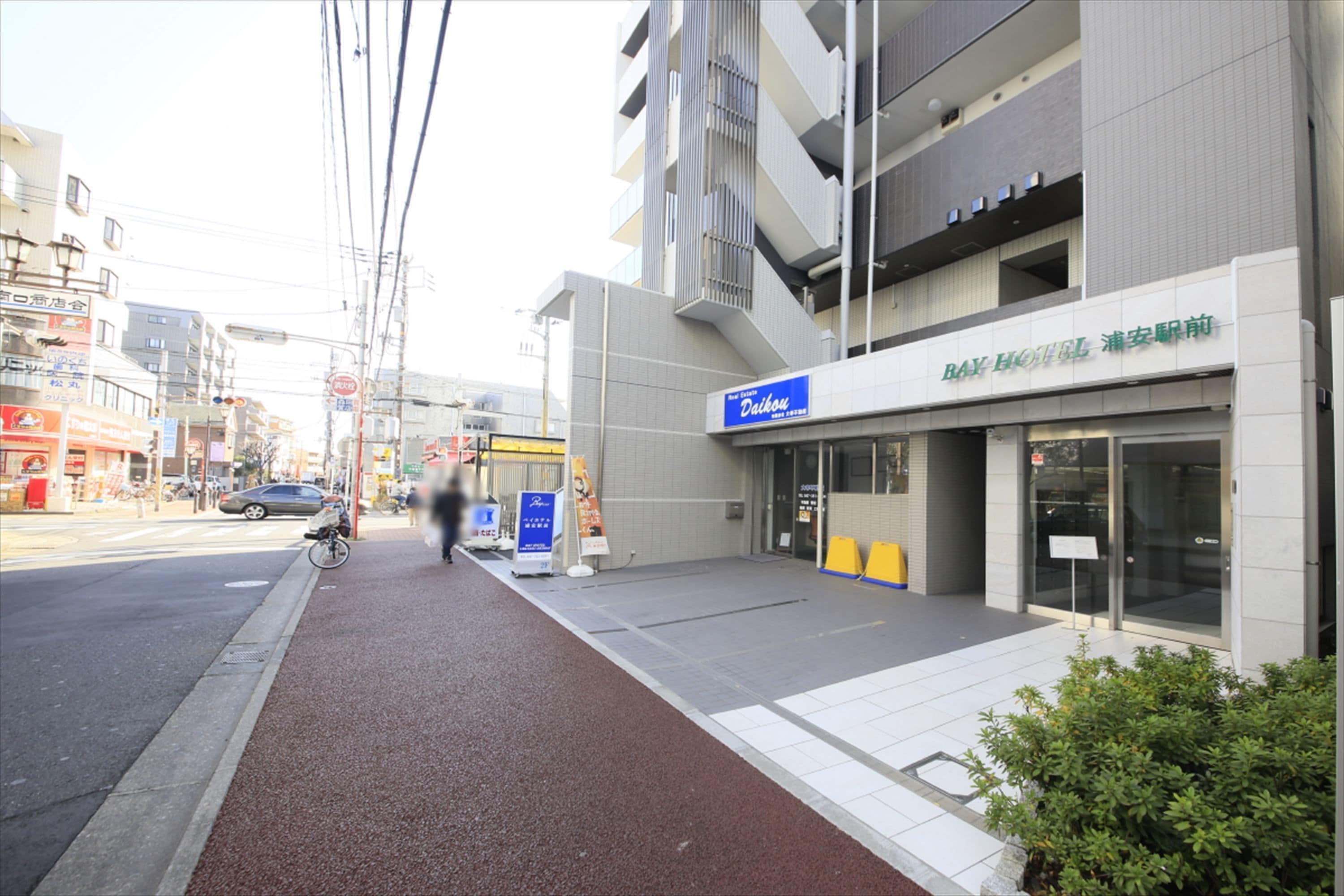 Un hotel con fachada moderna, una entrada visible y un carril bici contiguo al edificio.