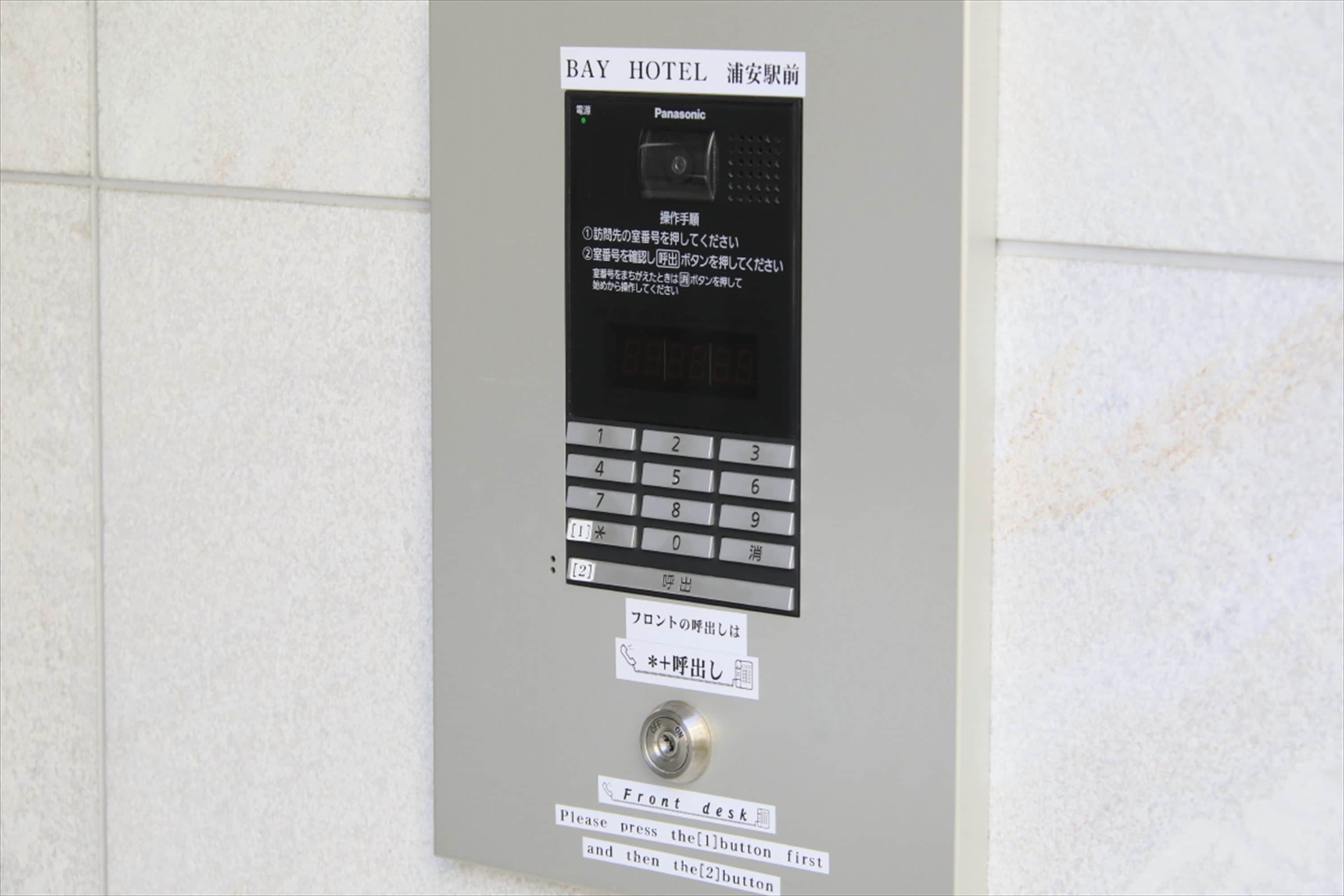 Un teclado digital con instrucciones en varios idiomas para acceder a la habitación de hotel.