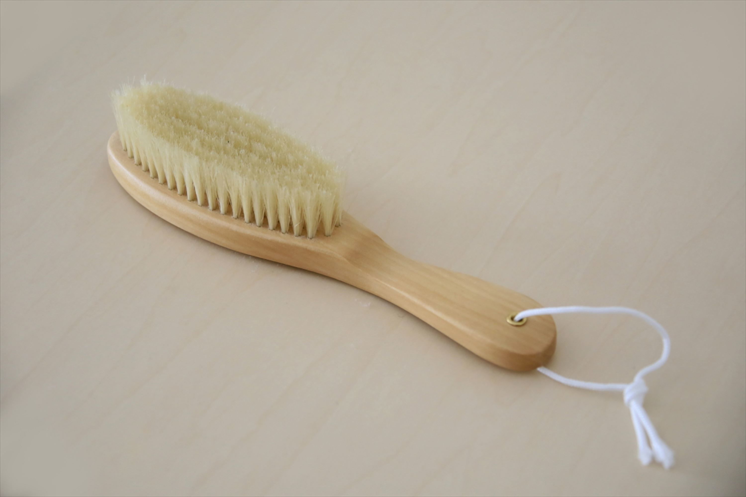 A wooden brush with a white string.