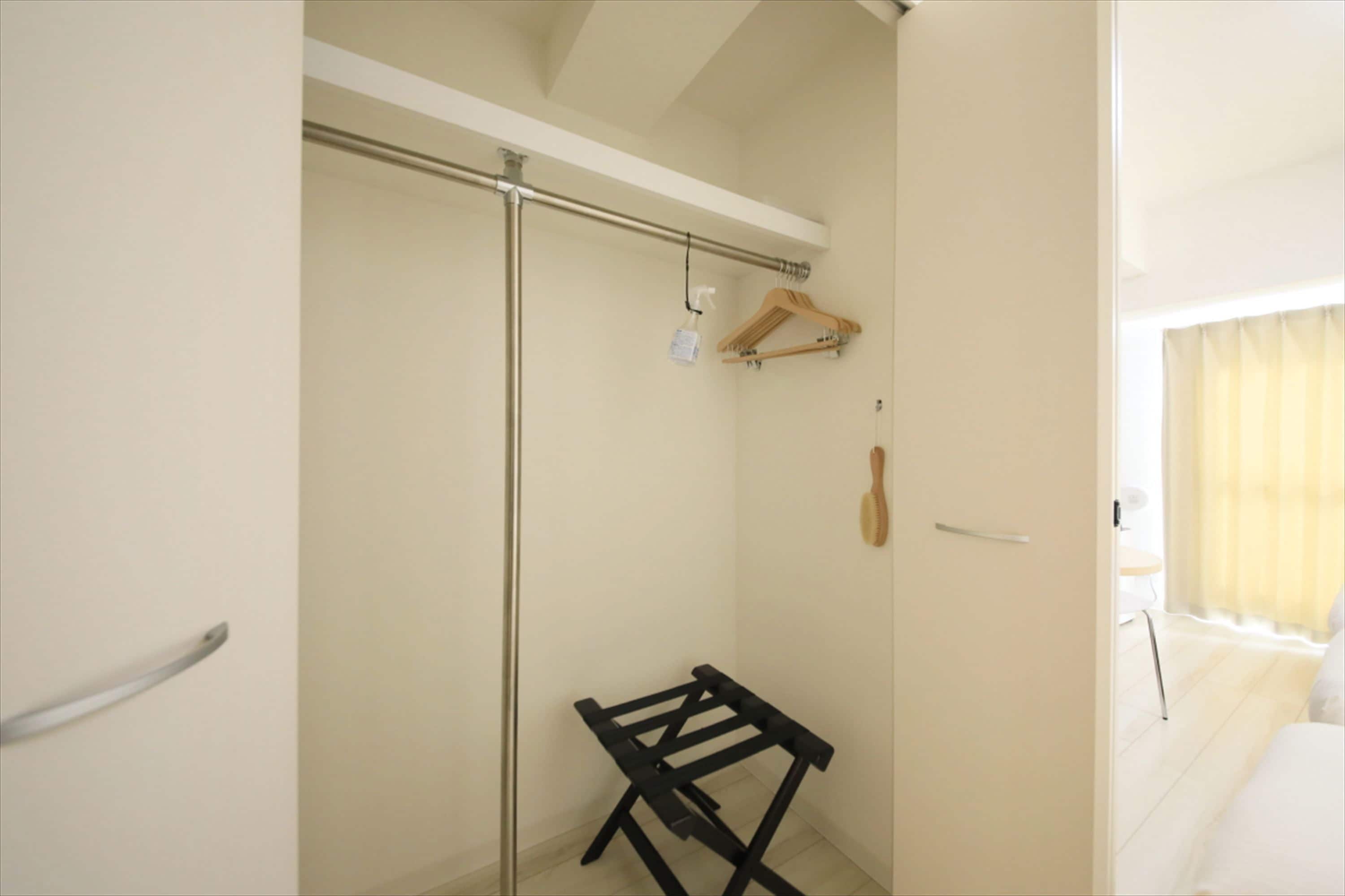Un bagno con doccia, un appendi asciugamani e un portabiti in legno.