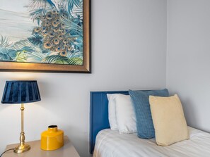 A hotel room with a bed, a nightstand, a lamp, and a painting. - Pink Blossom, Townhouse Clifden (Clifden)