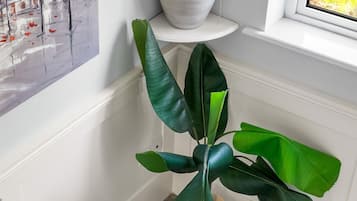Una escalera con una planta en maceta y un cuadro en la pared.