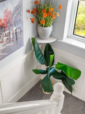 Un escalier orné d’une plante en pot et d’un tableau accroché au mur.