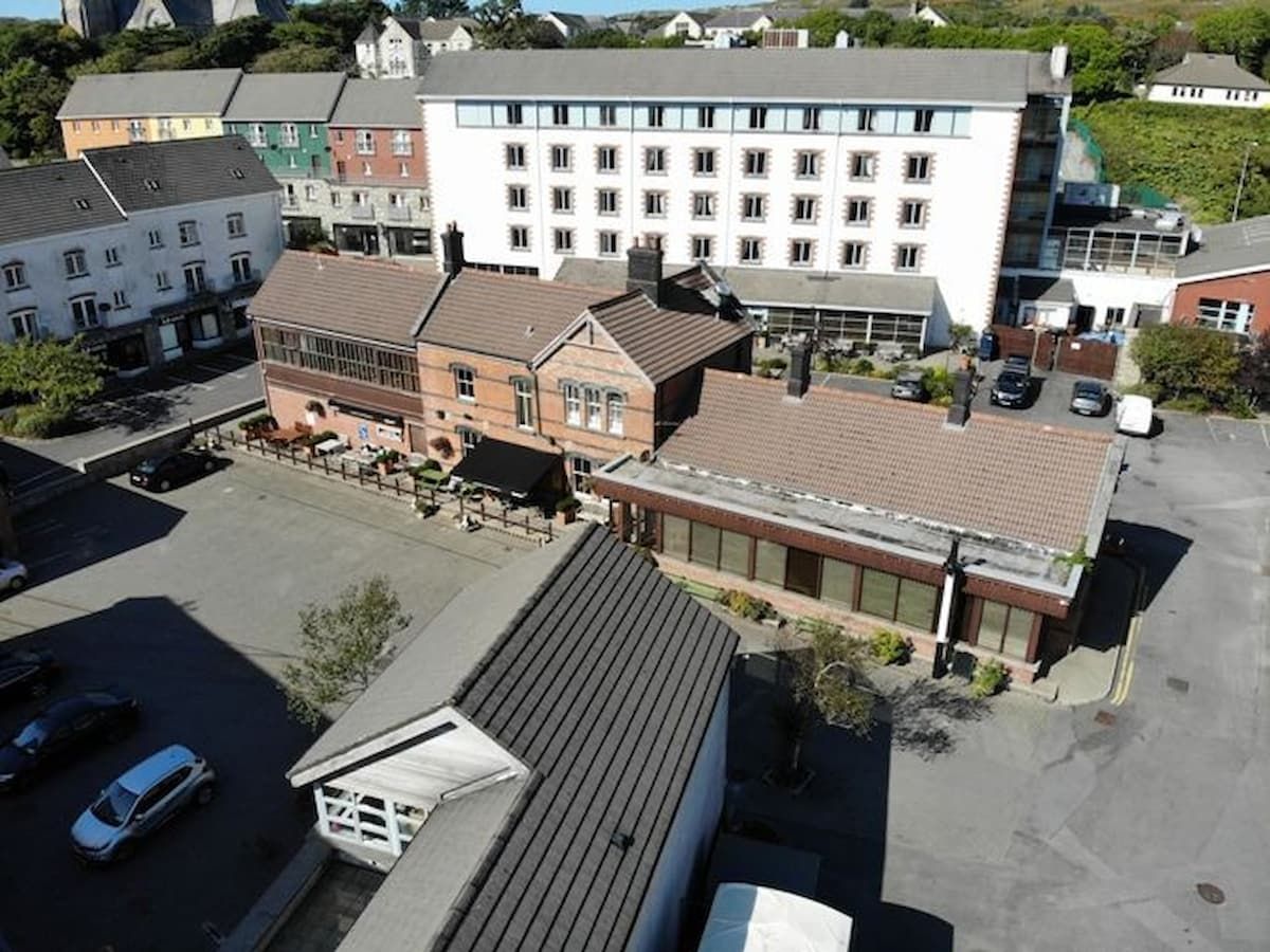 Ein mehrstöckiges Hotel mit Parkplatz davor.