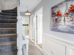 A staircase with white balusters leading to a room with a painting of a winter scene. - Pink Blossom, Townhouse Clifden (Clifden)