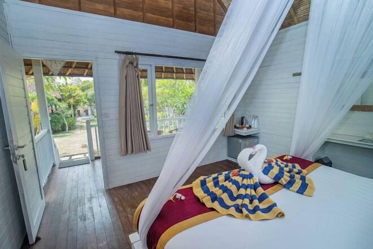 Une chambre à coucher avec un lit, un baldaquin et une vue sur l’extérieur.
