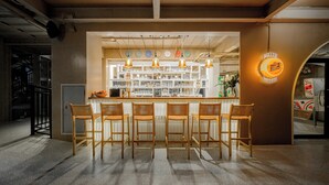 A bar area with wooden chairs, a counter with bottles, and a Miller sign. - Holiday Park Hotel (Koh Samui)
