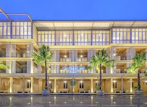 A multi-story hotel with a sign reading 'CENTRAL LIFE' and a pool area in front.