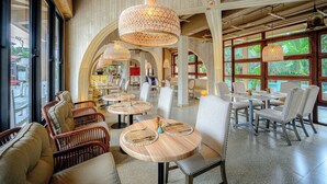 A restaurant with round tables, wicker chairs, and hanging lamps. - Holiday Park Hotel (Koh Samui)