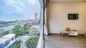 A balcony with a city view, a flat-screen TV mounted on the wall, and a small seating area with cushions. - The Shann Hotel Da Nang (Da Nang)