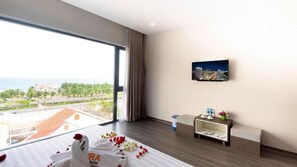 Deluxe kamer, uitzicht op zee | Een minibar, een kluis op de kamer, een bureau, geluiddichte muren