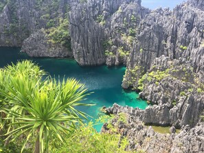 A coastal landscape with rugged cliffs and a clear turquoise sea.