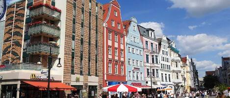 A bustling square with historic buildings, outdoor seating, and a McDonald's restaurant.