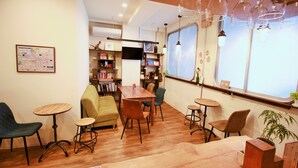 Un café acogedor con muebles de madera, una estantería y un amplio ventanal con vistas.