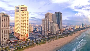 Un paisaje urbano costero con rascacielos, una playa y vista al océano.