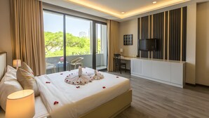 A modern hotel room with a large bed, a desk, and a TV. - Binh Duong Resident Hotel (Da Nang)