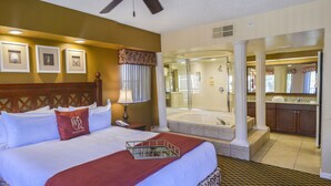 A hotel room with a large bed, a bathroom with a bathtub, and a kitchen area. - Orlando Condo (Orlando)