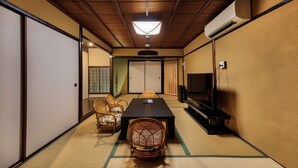 A traditional Japanese room with tatami flooring, a low table, and a television. - Kanade Fushimiinari (Kyoto)