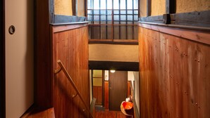 A wooden interior with a staircase leading to a lower level. - Kanade Fushimiinari (Kyoto)