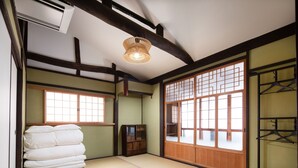 A traditional Japanese room with tatami flooring, a shoji screen, and a hanging light fixture. - Kanade Fushimiinari (Kyoto)