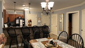 A dining area with a wooden table, black chairs, and a chandelier. - Scenic Mountain View, Comforts of Home, Footsteps from Downtown Gatlinburg (Gatlinburg)