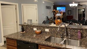 A kitchen with granite countertops, a dishwasher, double sinks, and wooden cabinets. - Scenic Mountain View, Comforts of Home, Footsteps from Downtown Gatlinburg (Gatlinburg)