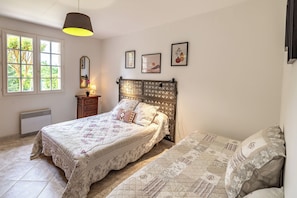 A bedroom with a bed, a bedside table, a lamp, a window, and wall art. - Les Lauriers - 8 pers. Single-storey family cottage with enclosed garden - Swimming pool (La Douze)