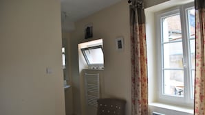 A bathroom with a toilet, a towel rack, a chair, and a window with curtains. - IDEAL FAMILY HOUSE (Bracieux)